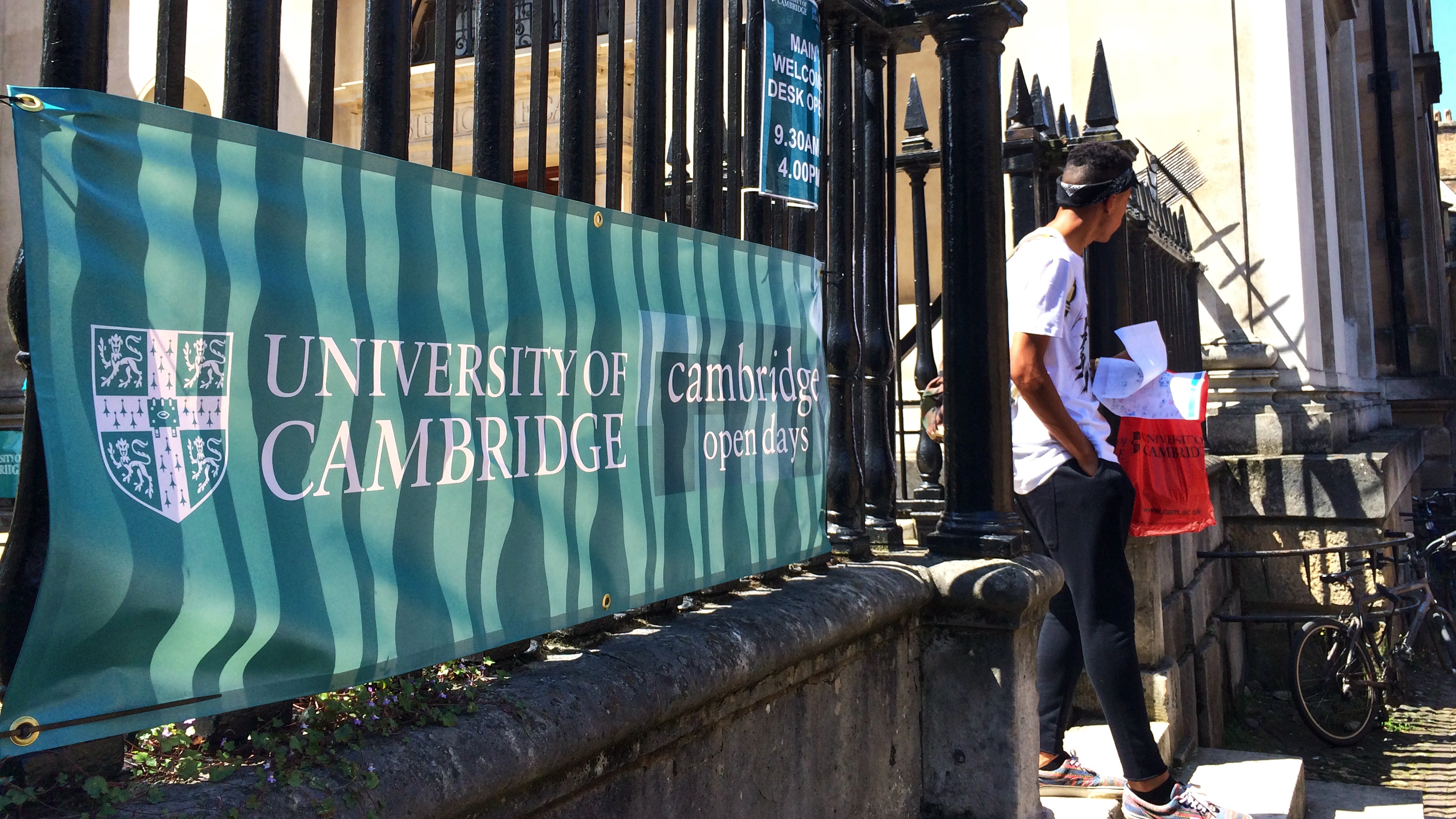 Teal banner reading "University of Cambridge" and "Cambridge open days" attached to metal railings